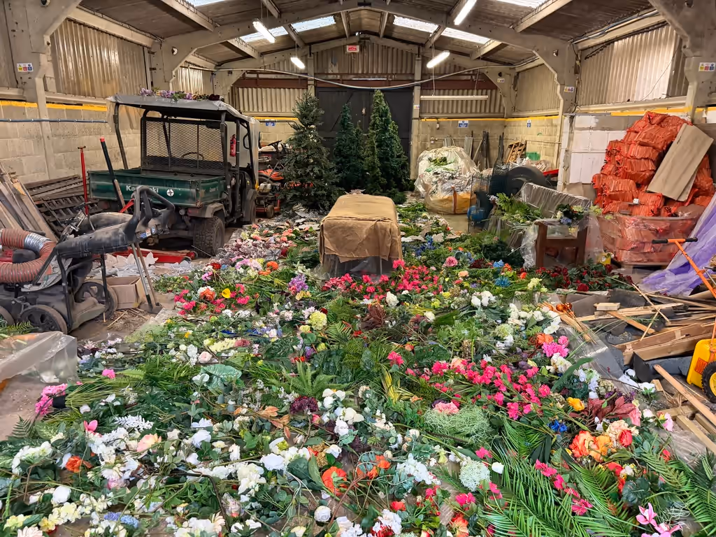 Fire-retardant-treated artificial flowers and foliage laid out for festive displays at a hotel