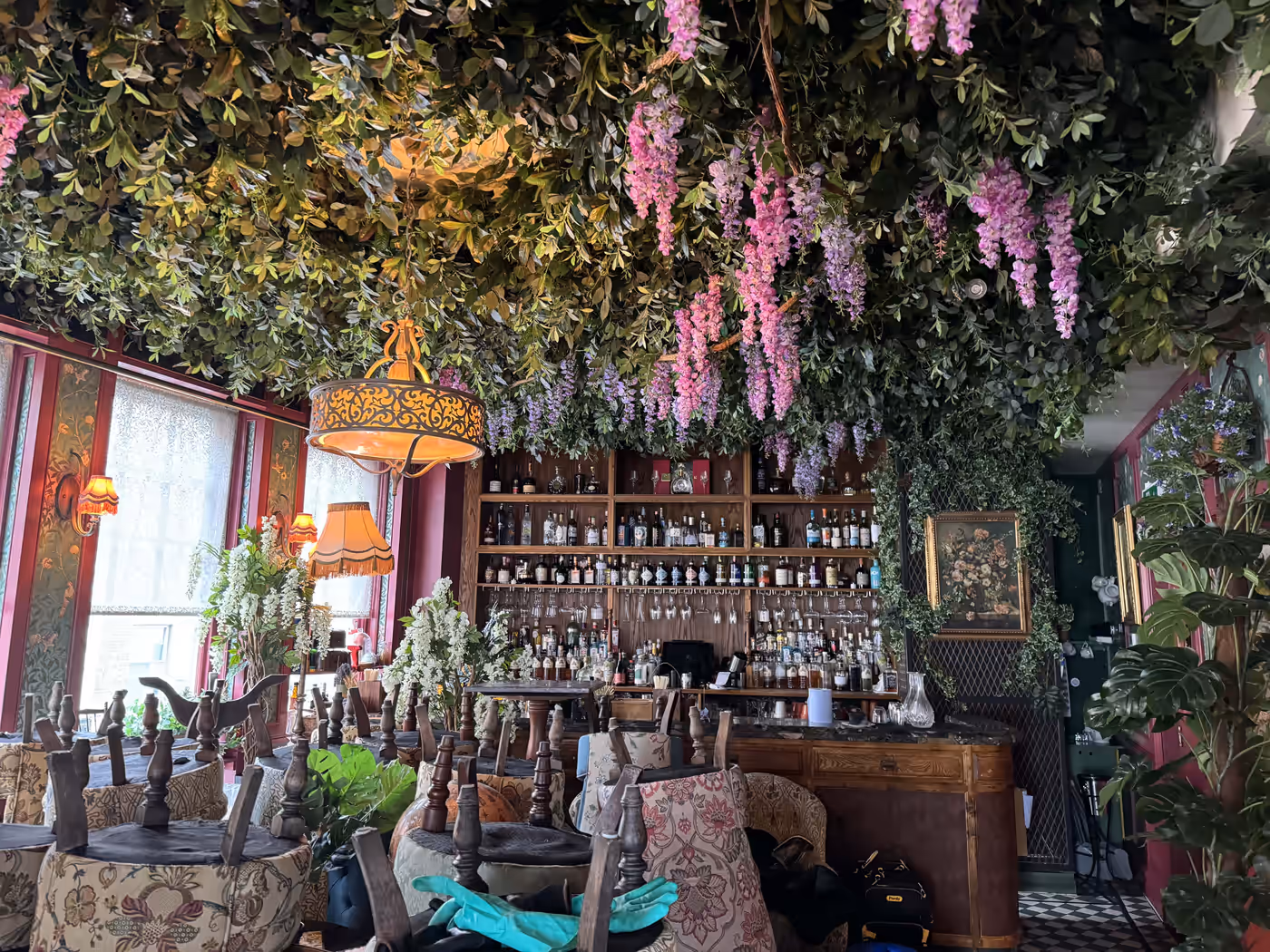 Dense artificial foliage installation across a restaurant ceiling