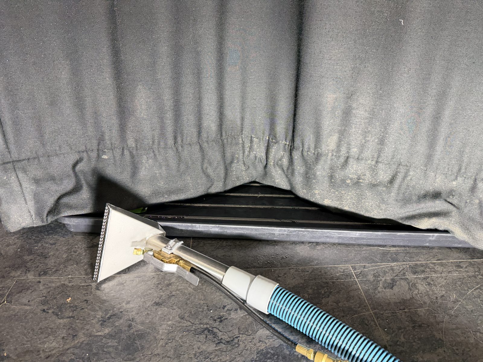 Specialist extraction cleaning around the stained lower edge of a venue curtain