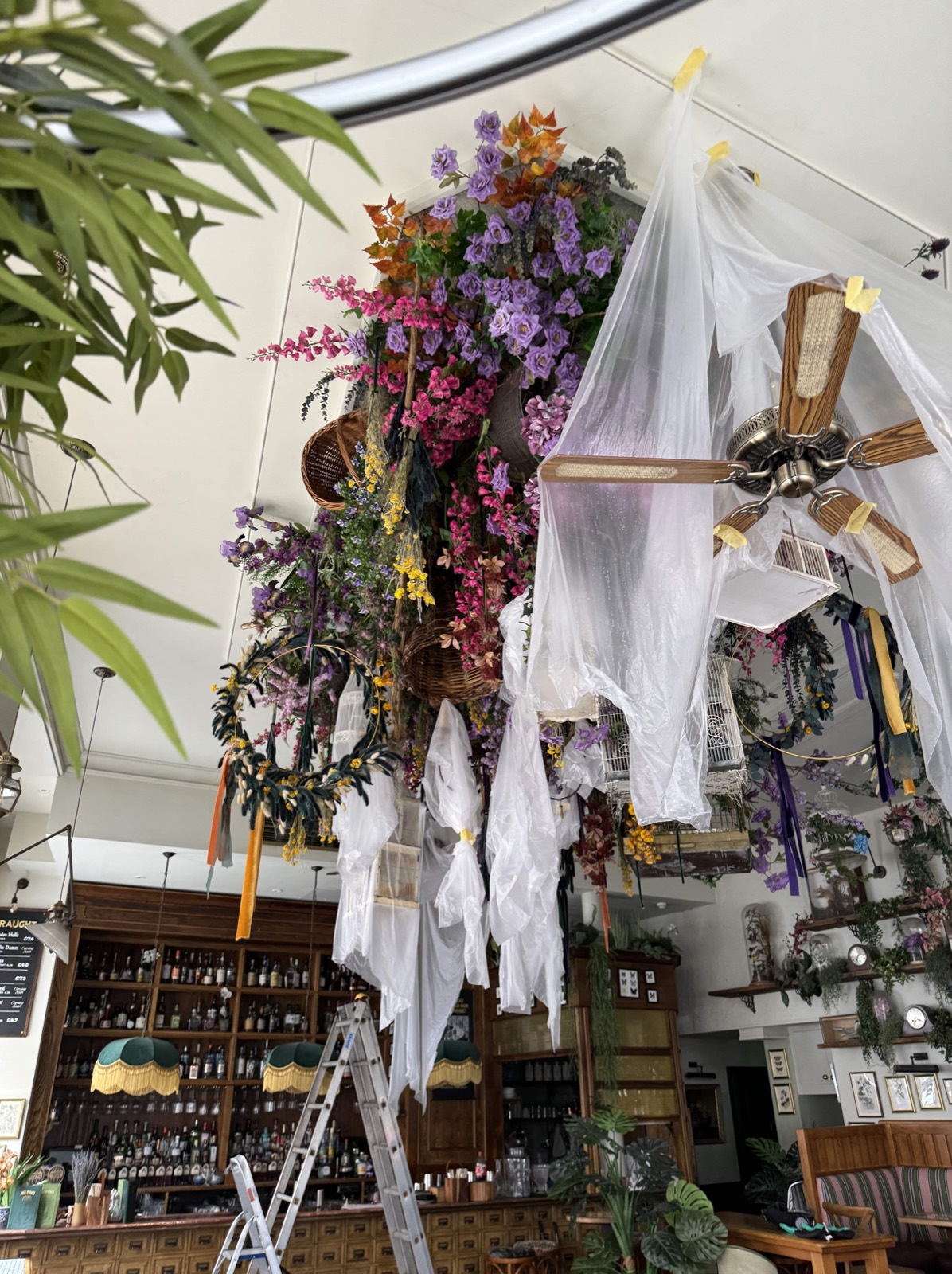 Large suspended floral installation prepared for on-site treatment in a hospitality venue