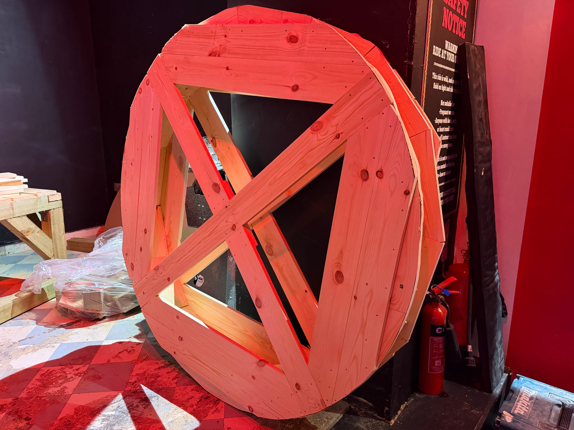 Large unfinished circular timber structure assembled inside a venue