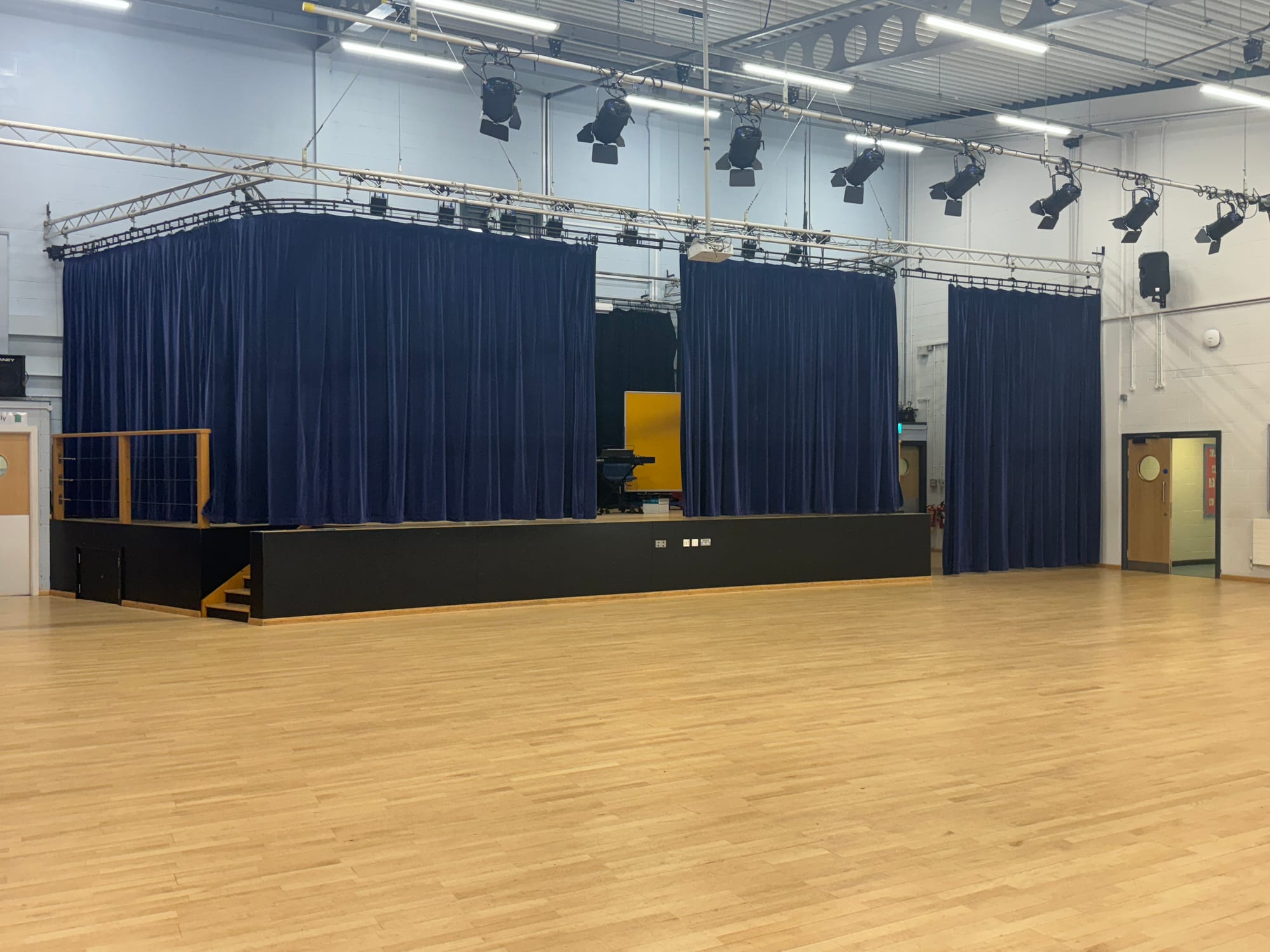 Blue stage curtains in a school performance space