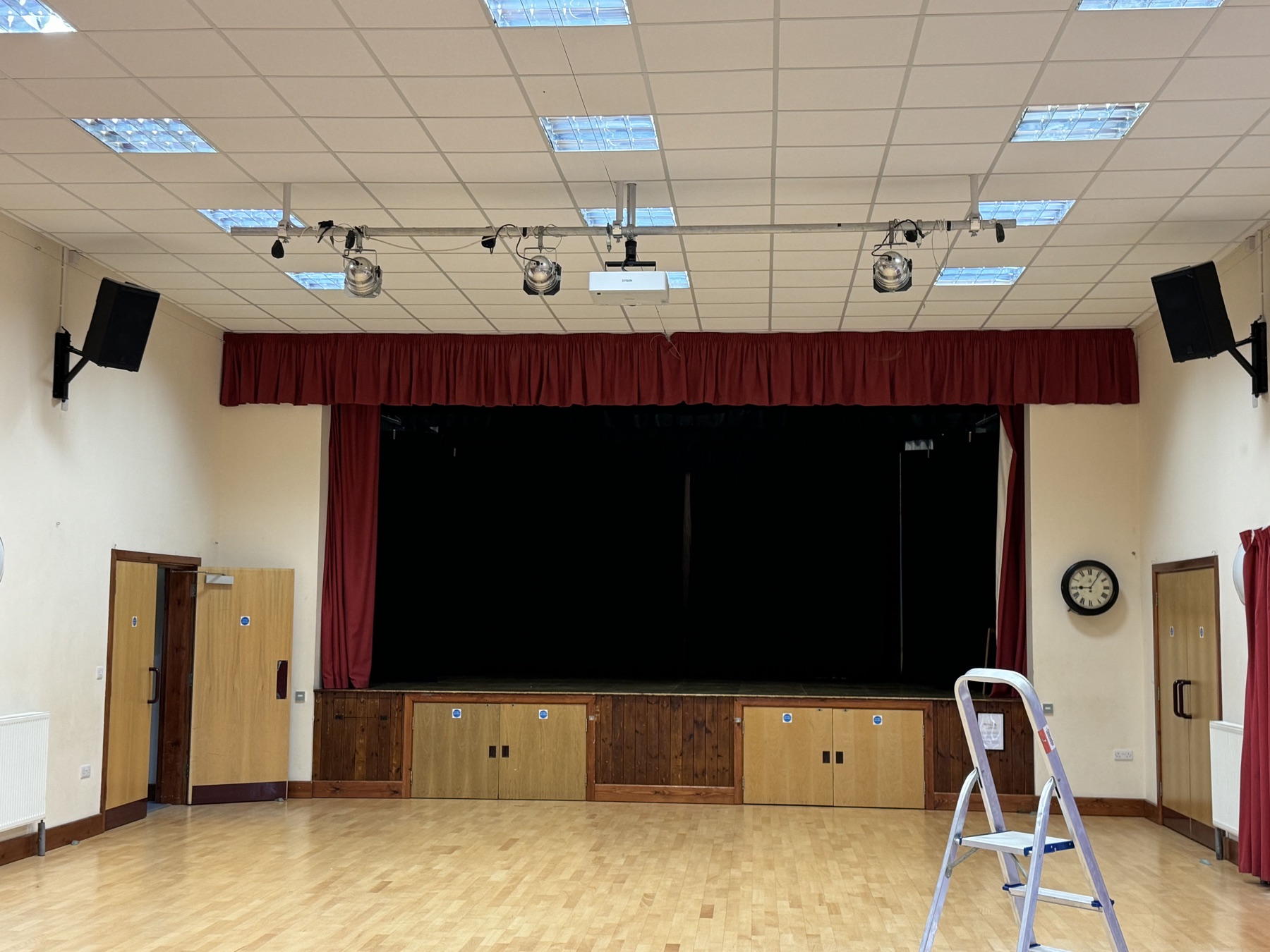 Red stage curtains in a village hall