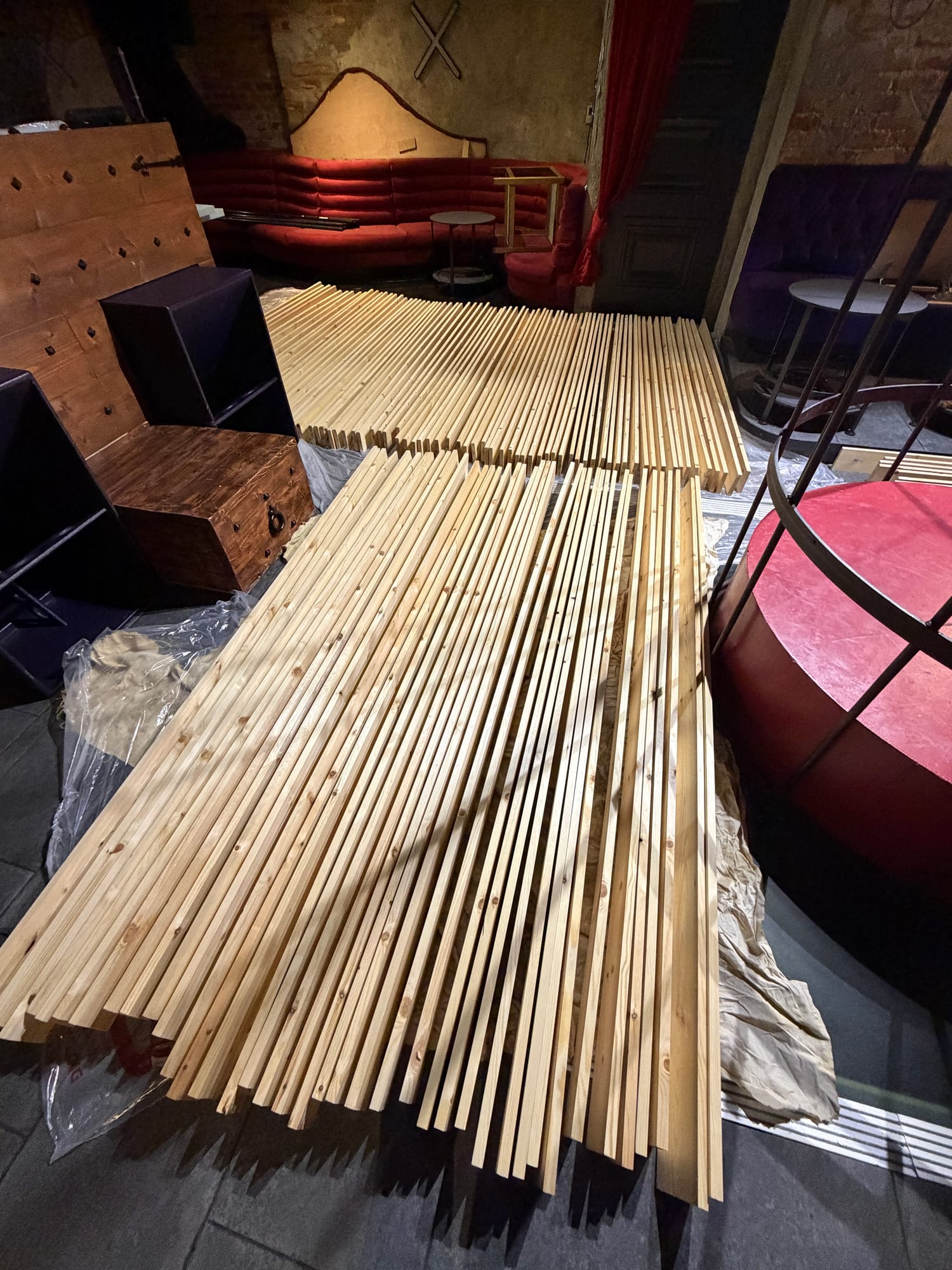 Long raw timber battens laid out inside a venue before treatment